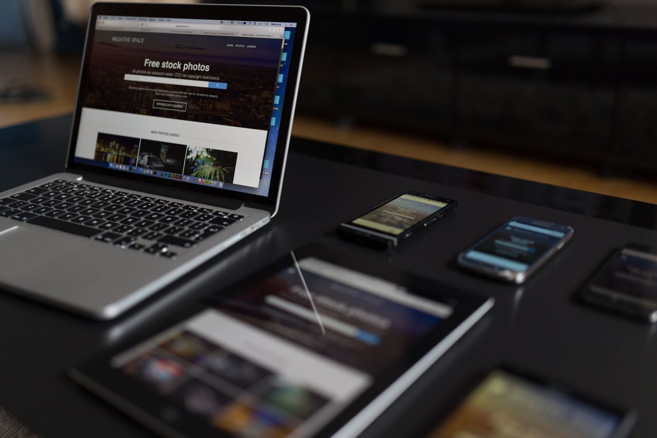 Un espace de travail contemporain présentant un ordinateur portable, une tablette et des smartphones, idéal pour un usage technologique et en freelance.